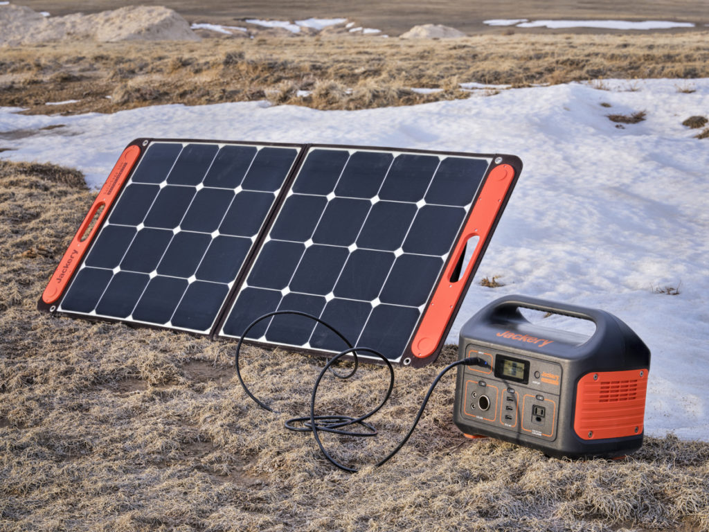 Jackery Explorer 500, 518Wh lithium Portable Power Station, is being charged by a solar panel in a remote location in Pawnee National Grassland, early spring scenery.