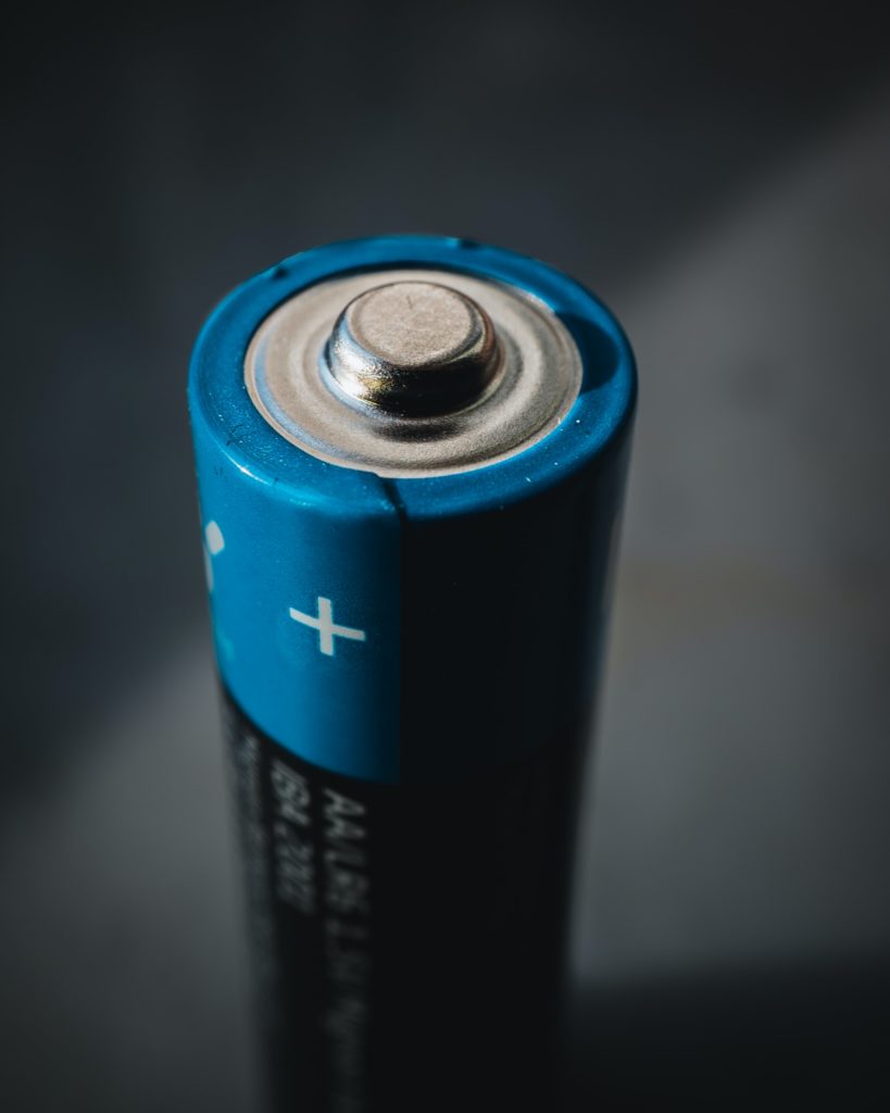 Close-up shot of a blue AA type battery cell on the + / cathode side